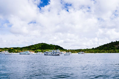 Boats sailing in sea against sky