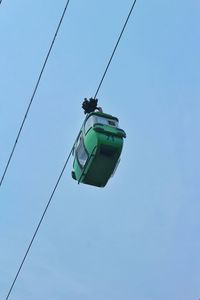 Low angle view of overhead cable car against clear blue sky