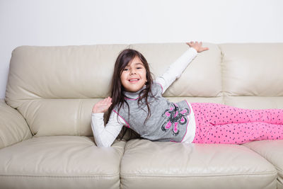 Portrait of smiling girl on sofa at home