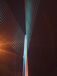 Low angle view of suspension bridge against sky at night