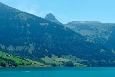 Scenic view of sea and mountains against sky