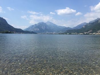 Scenic view of lake by mountains against sky