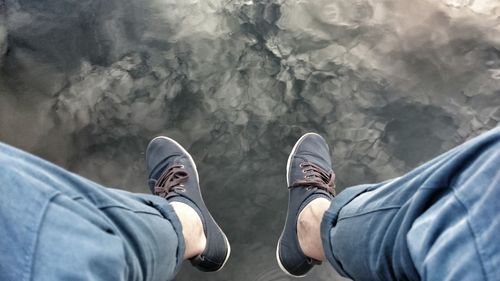 Low section of man sitting over lake