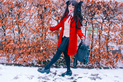 Full length of woman standing by tree during winter