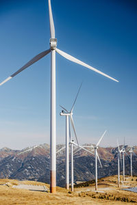 Wind turbines on land against sky