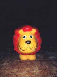 Close-up of toys on table against black background