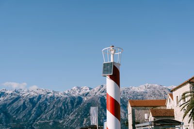 Built structure on snowcapped mountain against clear blue sky