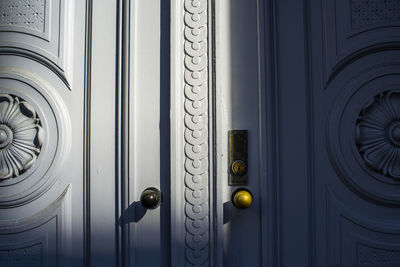 Full frame shot of closed white decorated door lit by sunlight