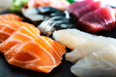 Close-up of sushi served on table against black background