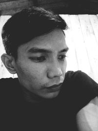 Close-up portrait of young man looking away at home