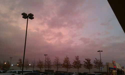 Low angle view of floodlight against sky during sunset