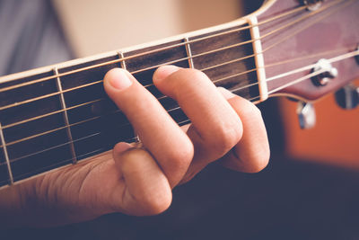 Close-up of hand playing guitar