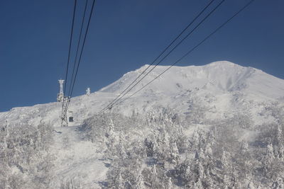 Overhead cable car over snowcapped mountains against sky