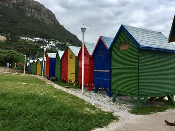 Beach huts by buildings against sky