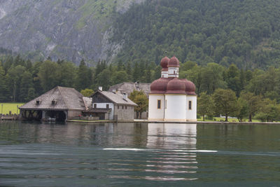 Built structure by lake against trees