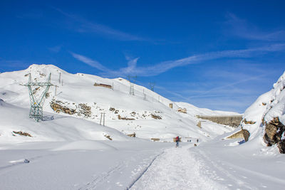 Scenic view of snowcapped mountains against blue sky