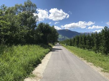 Road amidst trees against sky