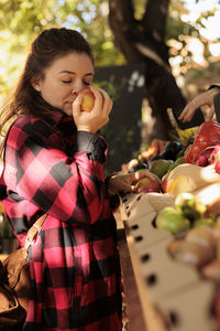 Side view of young woman holding food