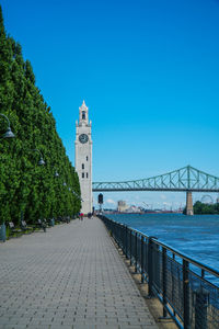 View of bridge over city against blue sky