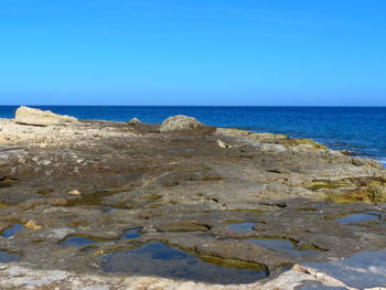 Scenic view of beach against clear blue sky