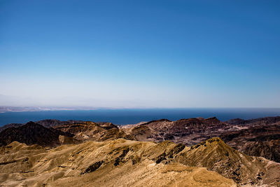 Scenic view of desert against clear blue sky