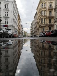 Reflection of buildings in puddle on road