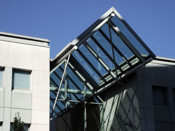 Low angle view of modern building against clear blue sky