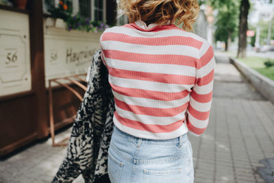 Midsection of woman walking on footpath