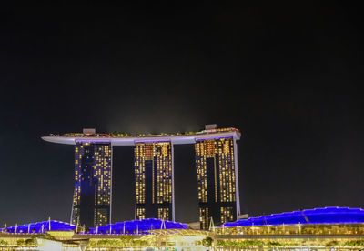 Low angle view of illuminated buildings against sky at night