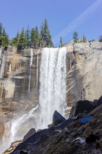 Low angle view of waterfall against sky