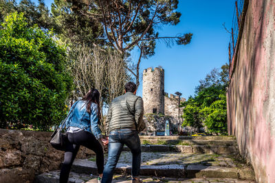 Rear view of women sitting against trees