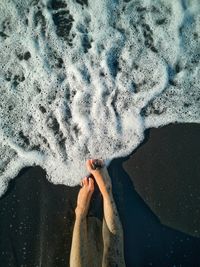 Low section of woman relaxing on beach