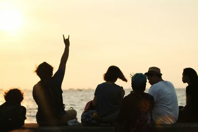 Silhouette of people sitting at sunset