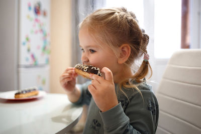 Portrait of girl holding ice cream at home