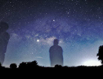 Silhouette man standing against star field at night