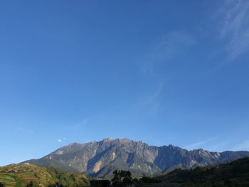 Scenic view of mountains against blue sky