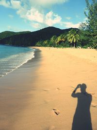 Shadow of man on beach against sky