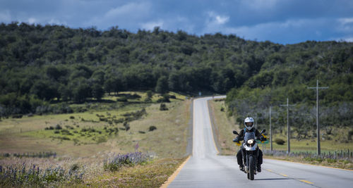 Woman driving her motorbike on lonely road in patagonia, chile