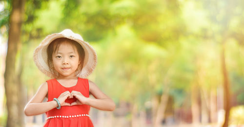Portrait of cute girl standing against blurred background