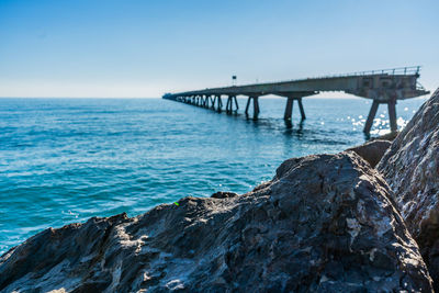 Bridge over sea against clear sky