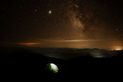 Scenic view of mountains against sky at night - milky way