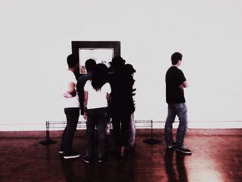 People standing on hardwood floor against clear sky