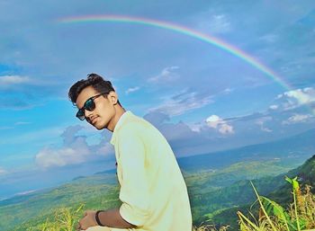 Rear view of man on rainbow against sky