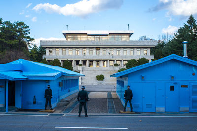 Rear view of man standing against blue sky