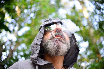 Low angle view of man wearing sunglasses against trees