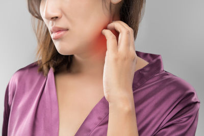 Midsection of woman itching on neck