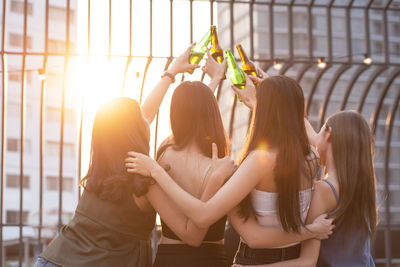 Rear view of women standing outdoors