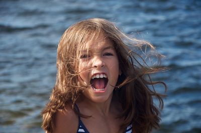 Angry girl shouting against sea