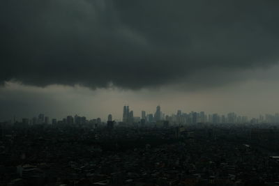 Buildings in city against cloudy sky