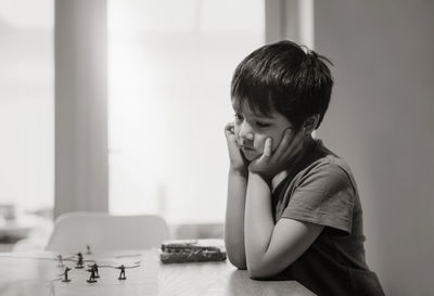 Portrait of boy looking at table at home